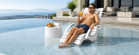 White in-pool lounge chair on a shallow tanning ledge beside luxury pool