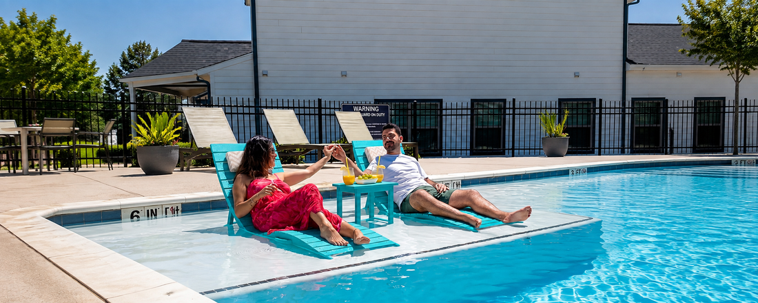 AquaCurve in-pool loungers on a shallow sun shelf with two people relaxing by the pool