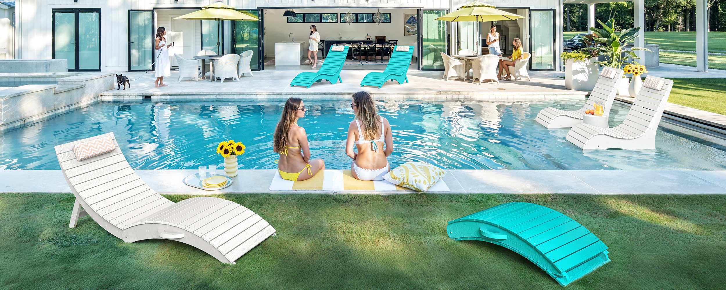 AquaCurve in-pool lounge chairs and table set around a modern backyard pool with shallow water and sun shelf seating