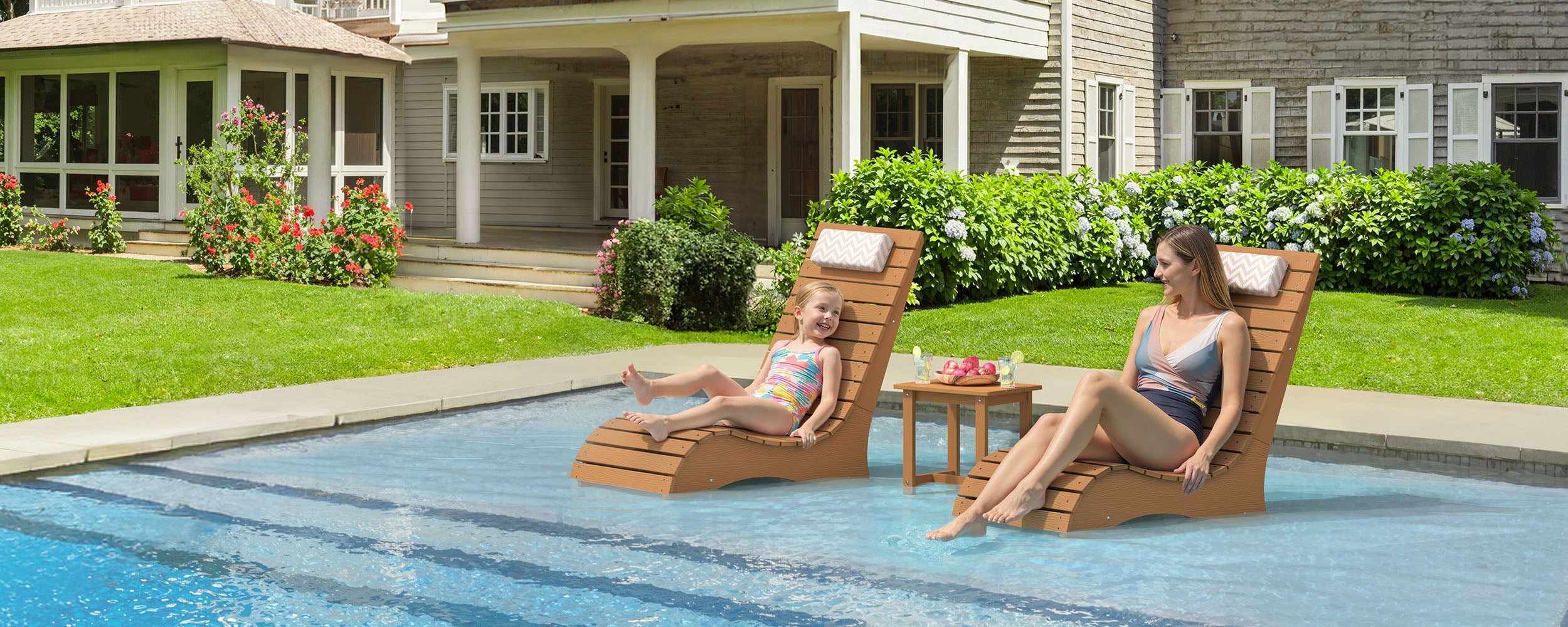 Two in-pool lounge chairs with a side table on a shallow sun shelf