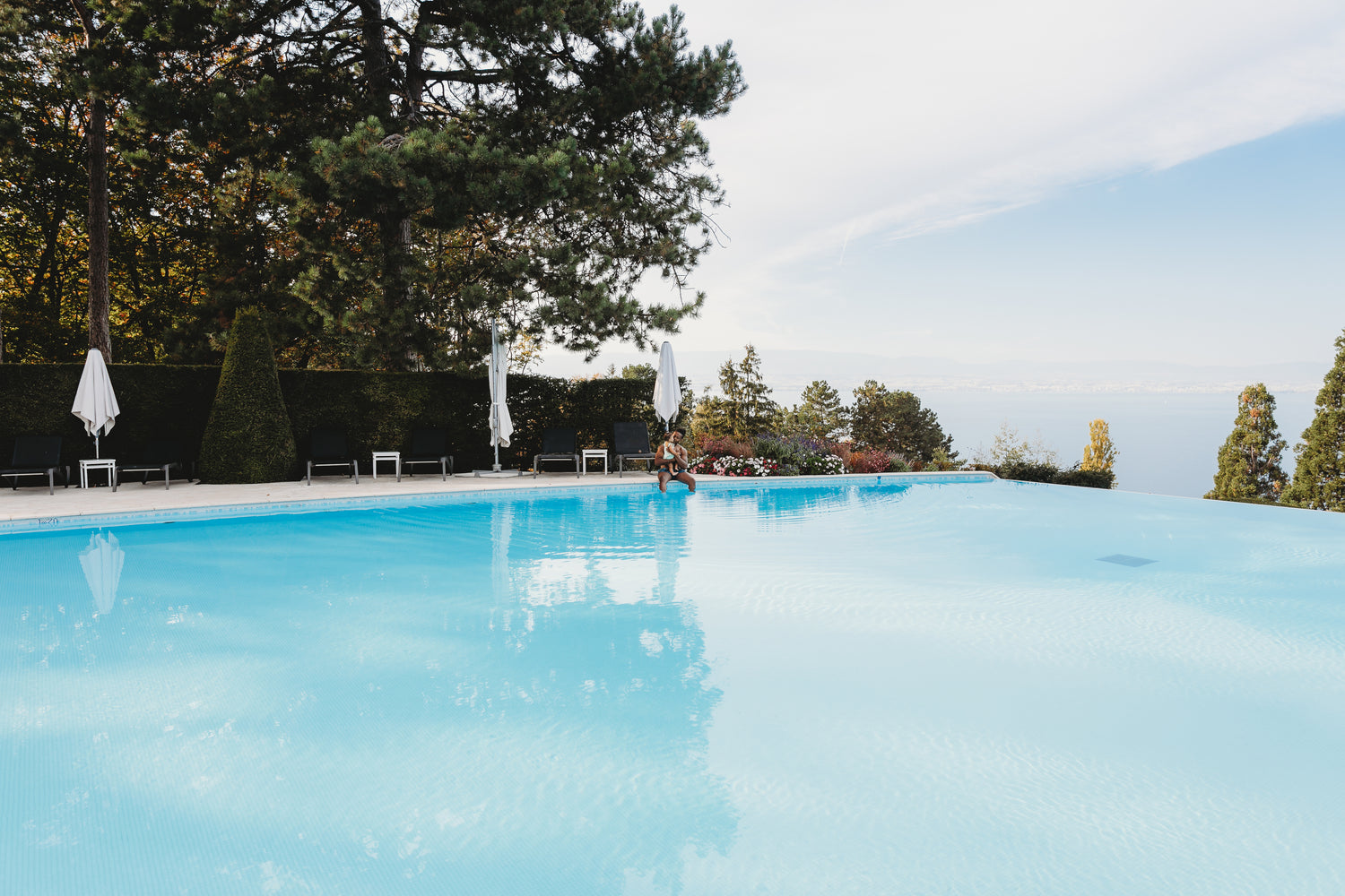 Infinity pool with wide shallow ledge area for in-water lounging layout