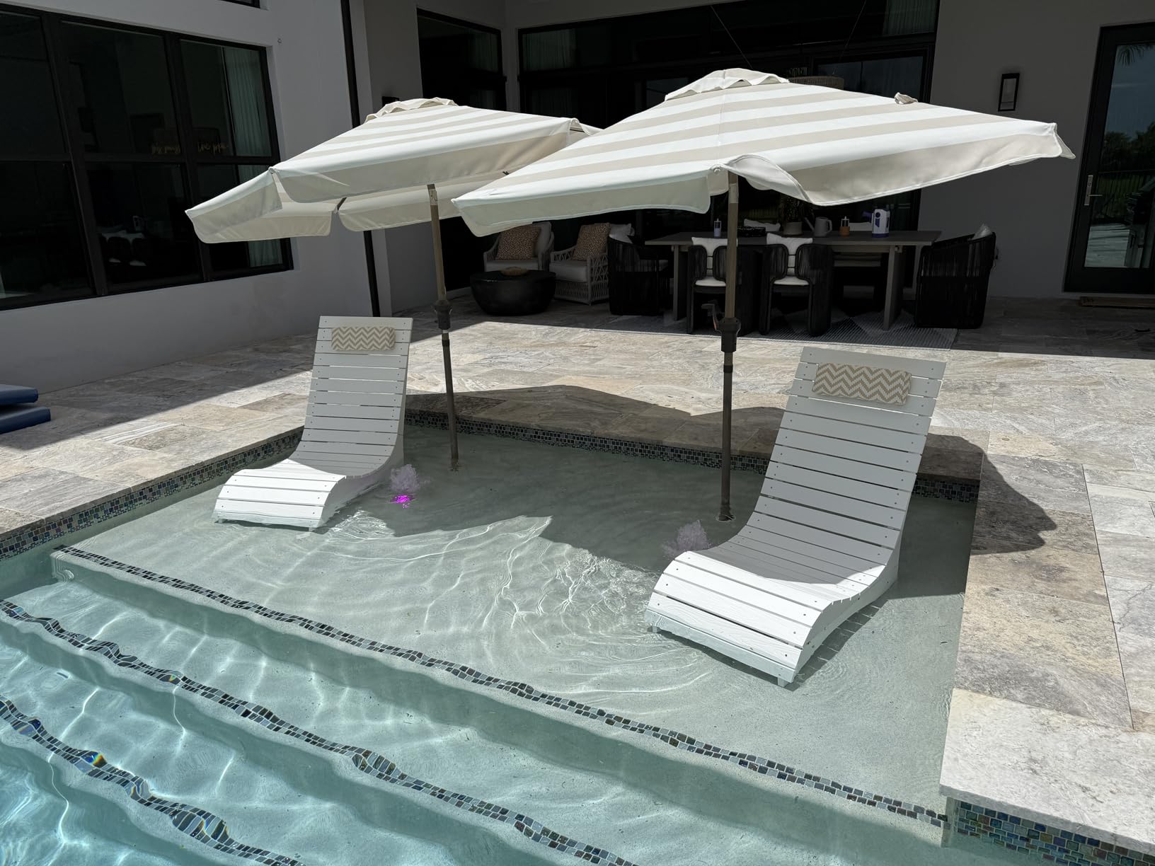 in-pool lounge chairs placed in water that appears too deep for a shallow shelf setup